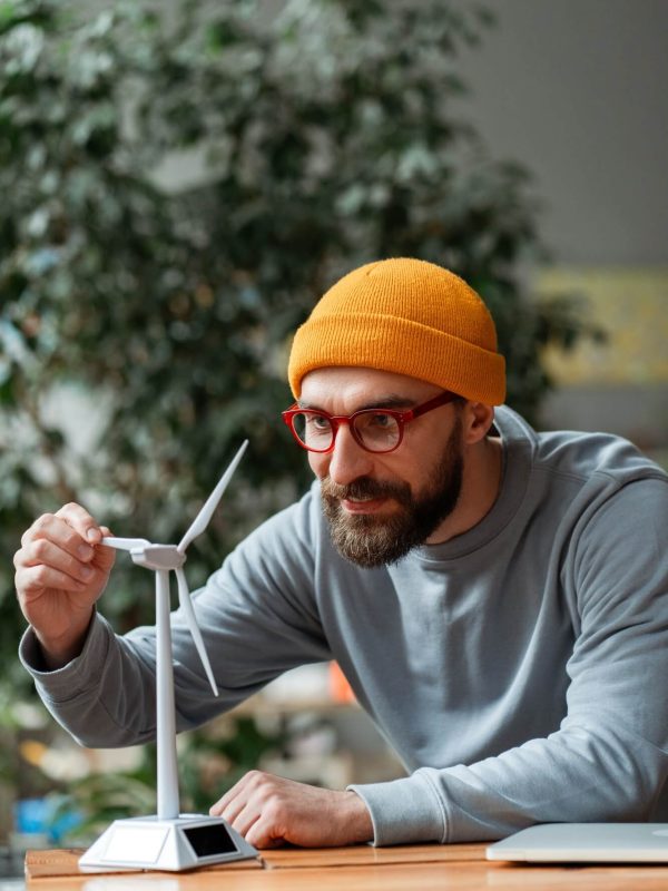 engineer-examining-small-wind-turbine-model-for-renewable-energy-project.jpg